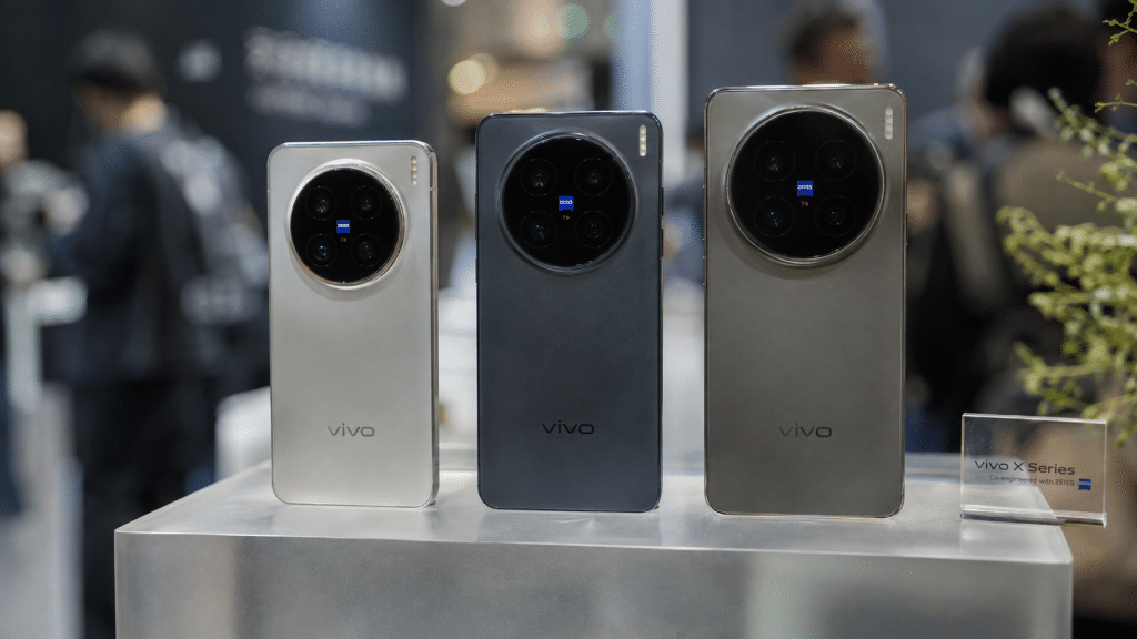 Jajaran tiga model Vivo X500 Series di atas meja etalase pameran teknologi Shanghai.